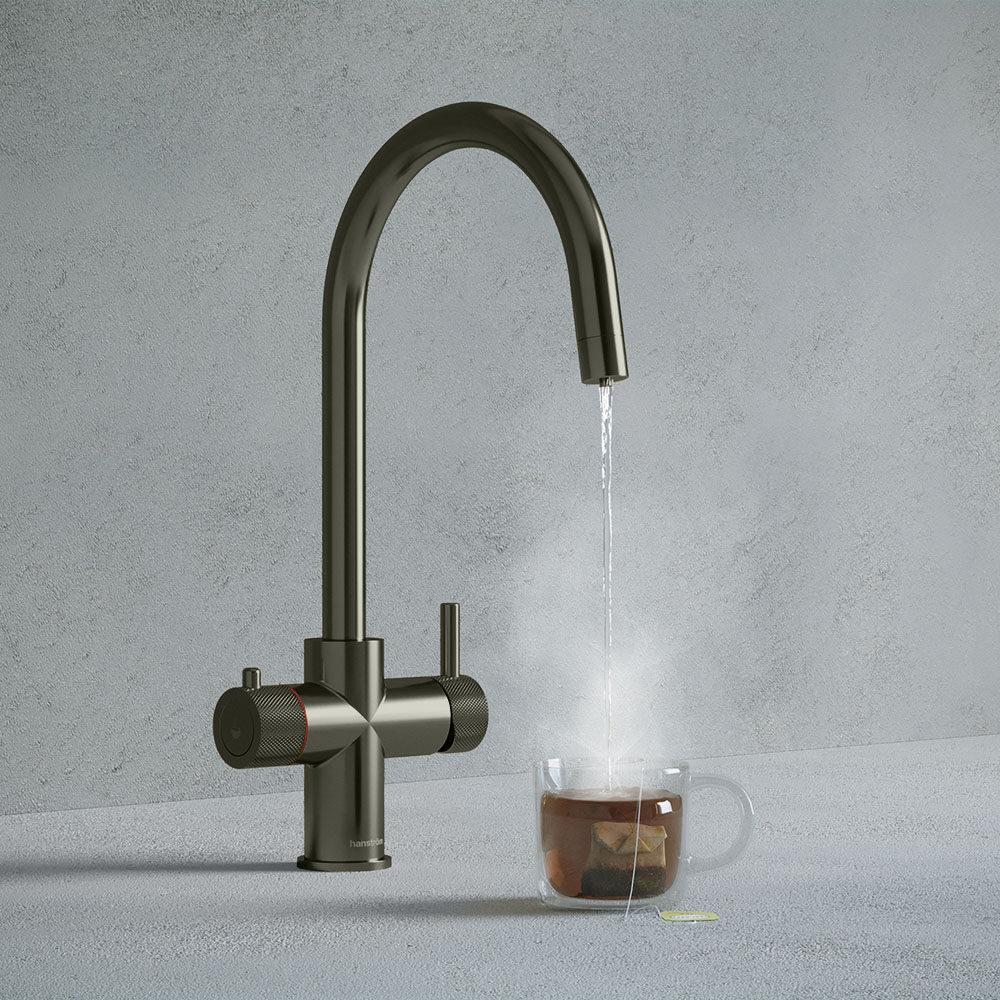 a gunmetal grey swan neck boiling water tap dispensing hot water to a cup of tea