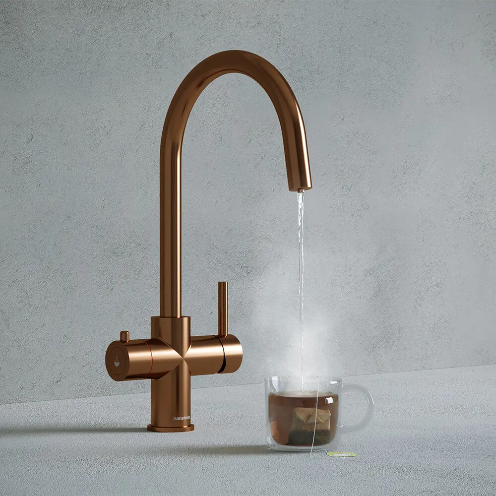 a brushed copper boiling water tap beside a teacup